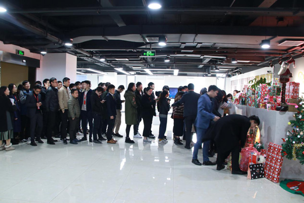 員工們?cè)谂抨?duì)抽取圣誕禮物 員工們?cè)谂抨?duì)抽取圣誕禮物